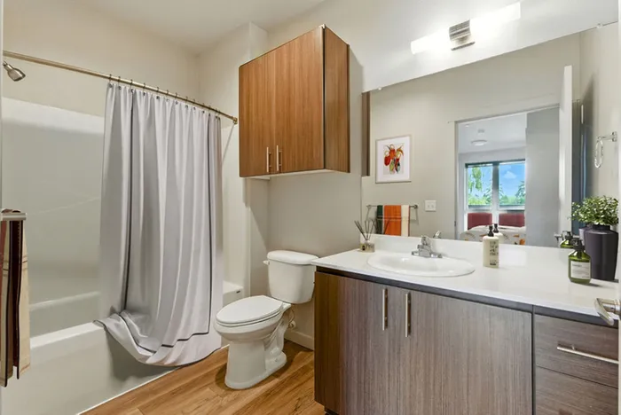 Sleek bathroom with modern fixtures, wood cabinetry, and a scenic view from the window, perfect for a tranquil retreat.