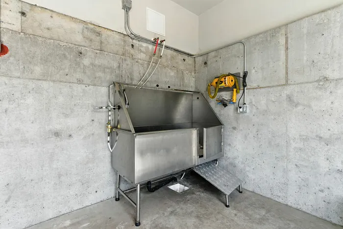 Modern stainless steel wash station in an industrial-style room with concrete walls, ideal for practical use in a sleek urban apartment.