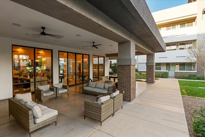 Chic outdoor patio with stylish wicker furniture and inviting glass doors leading to a modern interior.