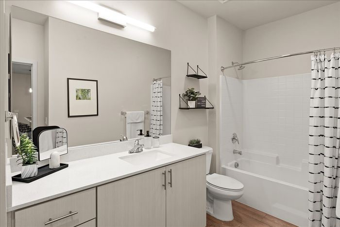 Elegant bathroom with modern fixtures, sleek white countertop, and stylish shelving complete with decorative plants.
