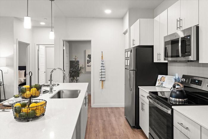 Modern kitchen with sleek appliances, elegant countertops, and stylish lighting, offering a warm and inviting atmosphere.