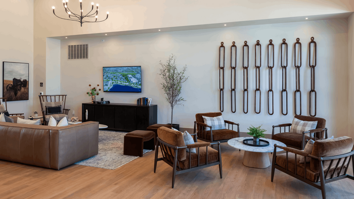 Luxury living room with modern decor, featuring a plush leather sofa, chic armchairs, a contemporary chandelier, and stylish wall art.