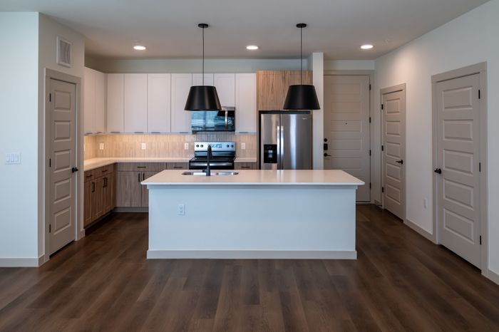 Modern kitchen with sleek cabinetry, stainless steel appliances, elegant island, and stylish pendant lighting.