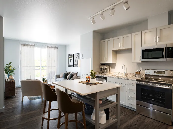 White cabinetry and stainless steel appliances in a prep-friendly kitchen at The Chandler | Your primary bedroom suite provides luxurious privacy with ensuite bathroom and walk-in closet convenience.  | The Chandler | Bedford Apartments