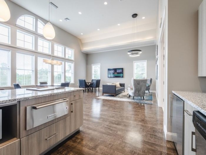 Open concept living area with wood plank style floor and stainless steel appliances | Apartments For Rent In Chelmsford MA | Mill and 3 Apartments