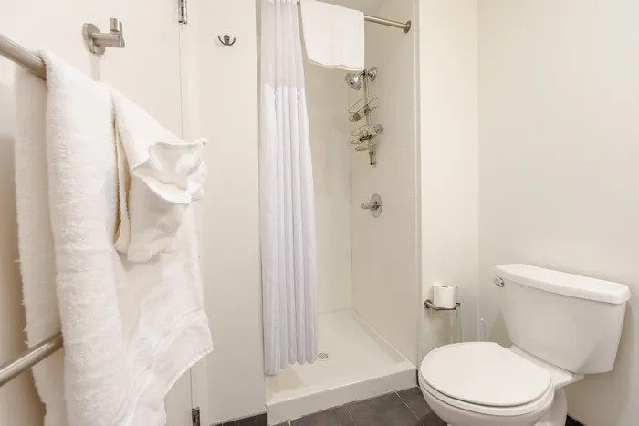 This primary bedroom with attached bath offers convenient privacy and comfort with ensuite bathroom access. | 381 Congress Lofts | Apartment in, Boston MA
