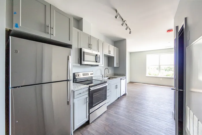Stainless steel appliances and white-on-white cabinetry in the kitchen at The Chandler |  The Chandler | Apartment in,Bedford NH