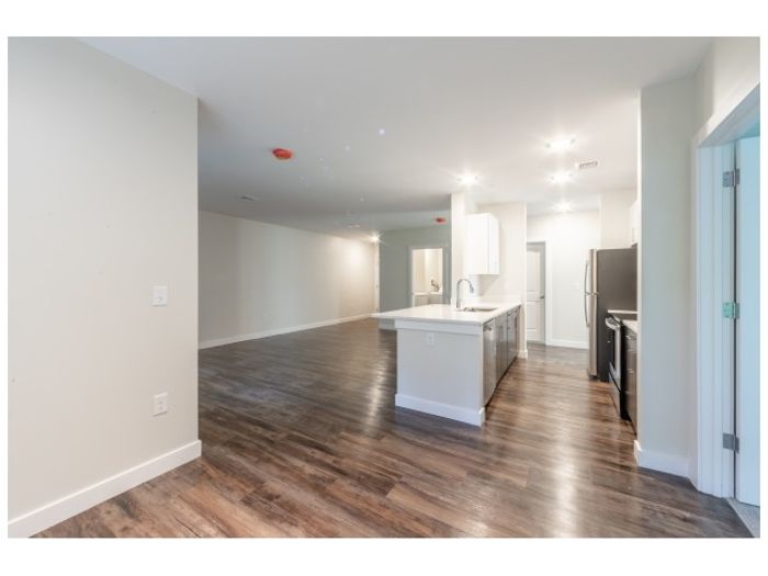 Open concept living area with plank-style flooring in apartment at the annex building at Dover Apartments in Dover, NH.