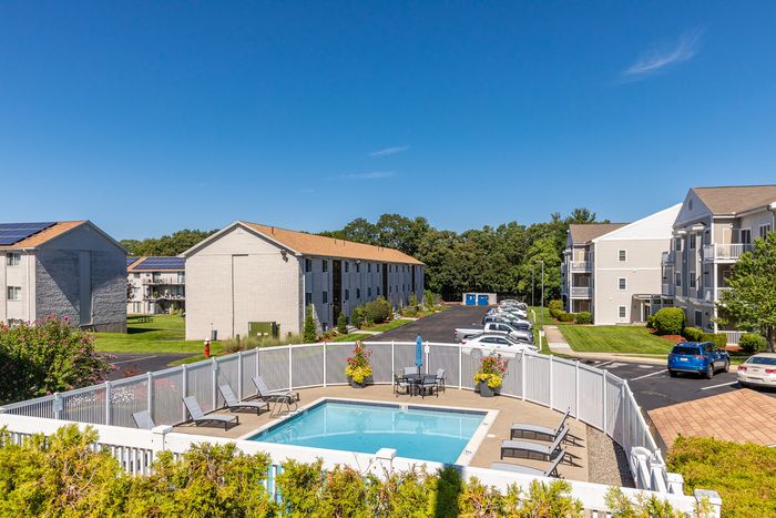 Cool off and enjoy the sunshine by the beautiful community swimming pool at our welcoming apartments in Dracut, MA. | Princeton Reserve | Dracut MA Apartments