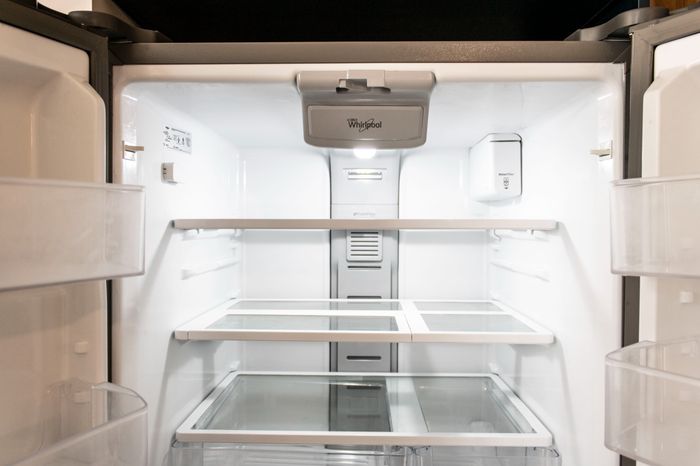 The James Apartments | Interior view of an open stainless steel refrigerator showing clean, empty shelves and door compartments | Luxury Apartments in Haverhill MA