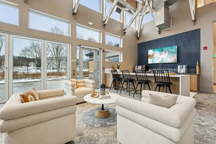 Chic lounge with modern furniture, large windows, and a stylish breakfast bar.