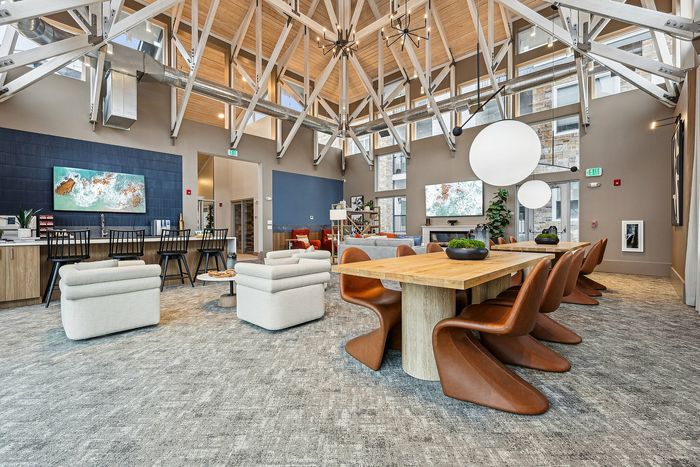 Spacious loft-style interior with modern furniture, natural lighting, and an open dining area.