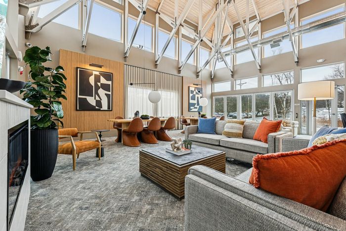 Spacious living room with high ceilings, large windows, and stylish decor with comfortable seating and a dining area.