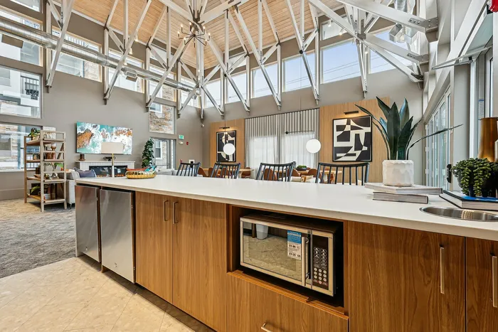 Bright and airy loft with modern decor, featuring a spacious kitchen island and cozy seating area with high ceilings and large windows.