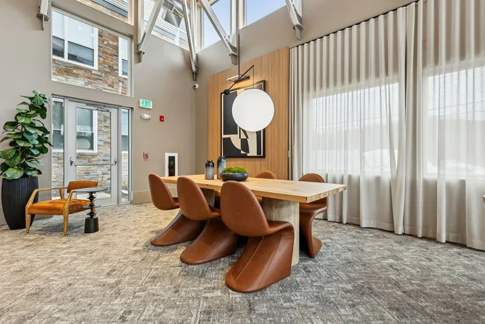 Elegant dining area with modern wooden table, stylish brown chairs, large window, and decorative elements.