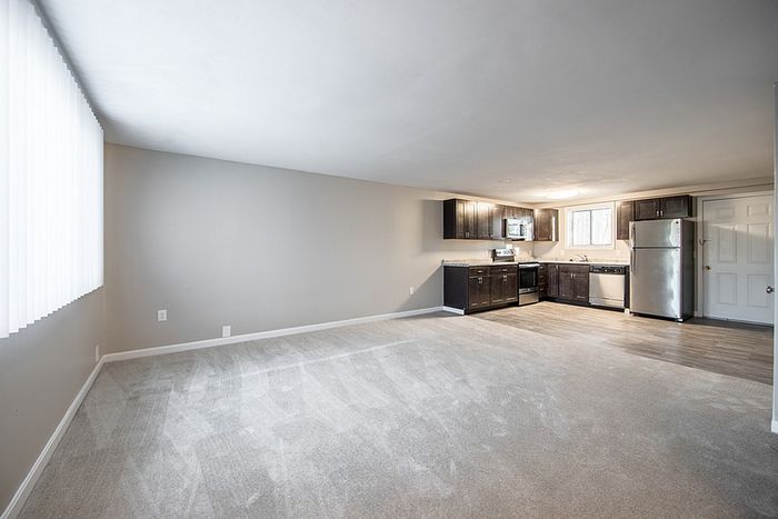Bright open-concept living space featuring modern kitchen with stainless steel appliances and sleek cabinetry.