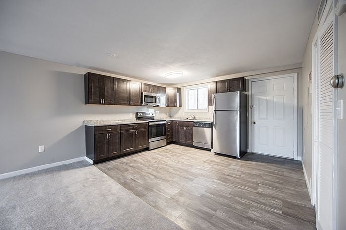 Modern kitchen with sleek dark cabinets, stainless steel appliances, and ample natural light.