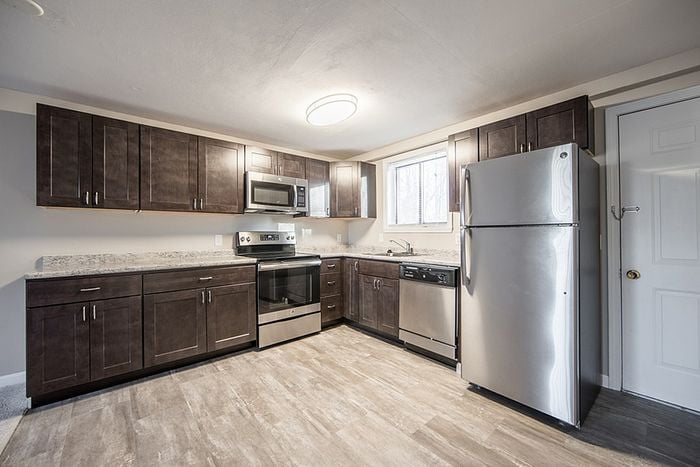 Modern kitchen with sleek dark cabinets, stainless steel appliances, and a bright, inviting atmosphere.