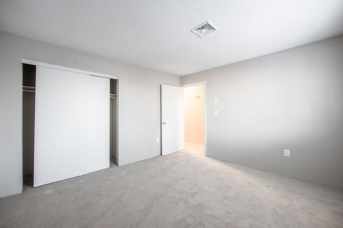 Bright and airy bedroom with plush carpet, ample closet space, and fresh, modern decor.