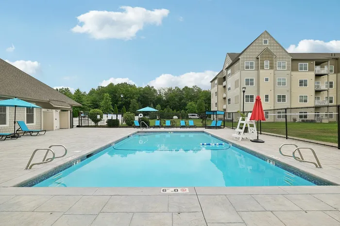 Enjoy sunny days lounging by the pristine, resort-style swimming pool at our scenic apartments in Westford, MA. | Princeton Westford | Luxury Apartments In Westford MA