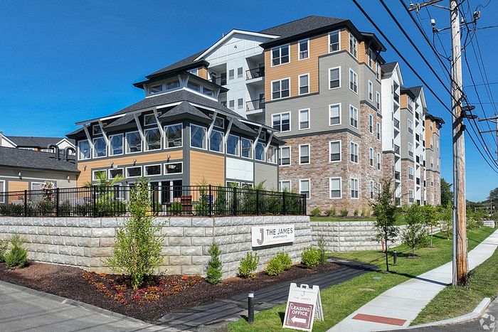 The James leasing office with a fence, a sign reading &ldquo;The James Apartments, and an A Frame reading &ldquo;leasing office&rdquo; with an arrow. The James Apartments is a notable residence in Haverhill MA. | The James | Apartment in, Haverhill MA
