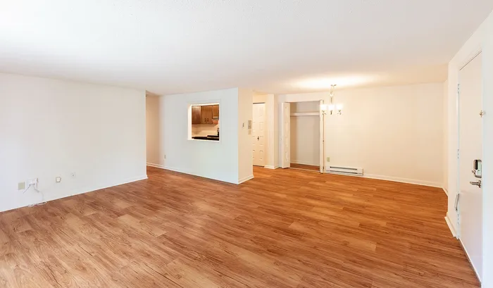 Bright and spacious living area with elegant wooden flooring and open layout, perfect for a modern lifestyle.| The Royal Crest | Apartment in North Andover, MA