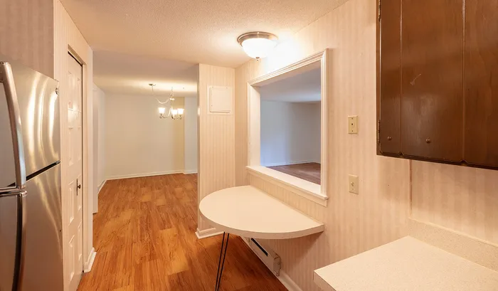 Inviting apartment interior with modern stainless steel appliances, elegant wood flooring, and a stylish open shelf design.Your spacious kitchen offers generous square footage with room for multiple people and all your cooking essentials. | The Royal Crest | Apartment in,North Andover MA
