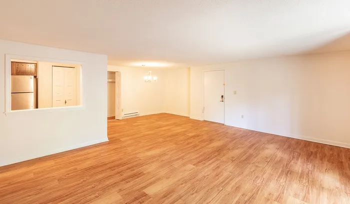 Spacious apartment with elegant hardwood flooring, an open-concept layout, and natural lighting from a large window.Your spacious kitchen offers generous square footage with room for multiple people and all your cooking essentials. | The Royal Crest | Apartment in,North Andover MA