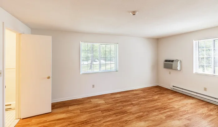 Bright and spacious room with large windows, hardwood floors, and clean white walls.Your spacious kitchen offers generous square footage with room for multiple people and all your cooking essentials. | The Royal Crest | Apartment in,North Andover MA