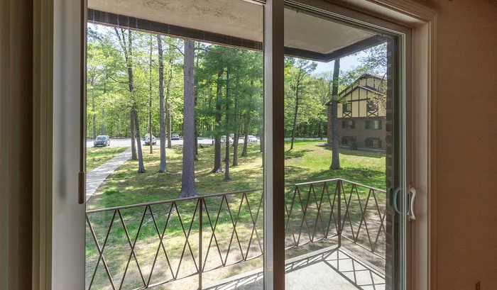 Bright and inviting view from a modern apartment balcony, overlooking lush green trees and a picturesque courtyard.Your spacious kitchen offers generous square footage with room for multiple people and all your cooking essentials. | The Royal Crest | Apartment in,North Andover MA