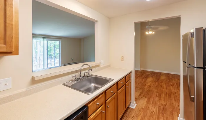Inviting kitchen space with stainless steel appliances, elegant wooden cabinets, and a modern open-pass design inviting natural light.Your spacious kitchen offers generous square footage with room for multiple people and all your cooking essentials. | The Royal Crest | Apartment in,North Andover MA