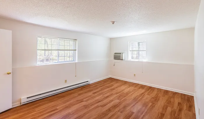 Bright, airy room with natural light, featuring elegant wooden flooring and large windows for a welcoming atmosphere.Your spacious kitchen offers generous square footage with room for multiple people and all your cooking essentials. | The Royal Crest | Apartment in,North Andover MA