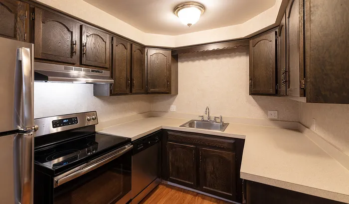 Inviting kitchen with rich wood cabinetry, modern stainless steel appliances, and ample countertop space.Your spacious kitchen offers generous square footage with room for multiple people and all your cooking essentials. | The Royal Crest | Apartment in,North Andover MA