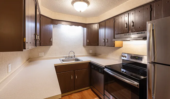 Charming kitchen with rustic brown cabinetry, modern appliances, and ample counter space.Your spacious kitchen offers generous square footage with room for multiple people and all your cooking essentials. | The Royal Crest | Apartment in,North Andover MA