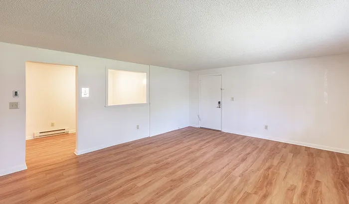 Bright and spacious room featuring elegant wood flooring, neutral walls, and an inviting entrance, perfect for creating a cozy home.Your spacious kitchen offers generous square footage with room for multiple people and all your cooking essentials. | The Royal Crest | Apartment in,North Andover MA