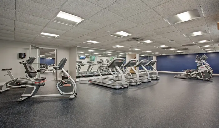 A bright and clean exercise room features contemporary equipment and mirrors, perfect for tracking your fitness progress. | The Royal Crest | Apartment in North Andover, MA