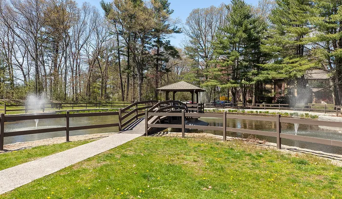 Serene park setting with a picturesque pond, charming gazebo, and tranquil fountains surrounded by lush greenery.| The Royal Crest | Apartment in North Andover, MA