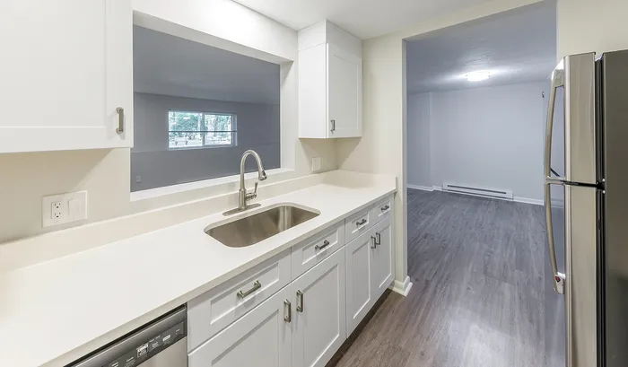 Modern kitchen with sleek countertops, stainless steel appliances, and an open view to a spacious living area.Your spacious kitchen offers generous square footage with room for multiple people and all your cooking essentials. | The Royal Crest | Apartment in,North Andover MA