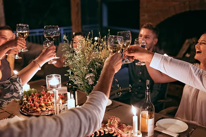 Charming dinner party scene with friends toasting around a candlelit table adorned with elegant floral arrangements and delectable appetizers | Princeton on Beacon Street | Princeton on Beacon Street Apartments
