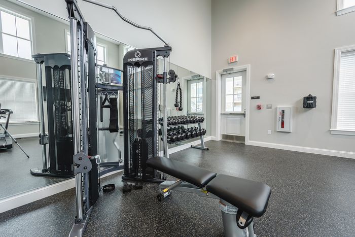 Maintain your fitness routine at our well-appointed gym featuring diverse equipment options for every workout preference. | Mill & 3 Apartments | Mill & 3 Apartments Apartments