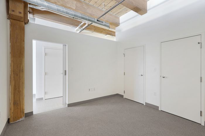 The airy bedroom provides bright, open atmosphere with natural light and comfortable proportions throughout. | 381 Congress Lofts | Boston Apartments