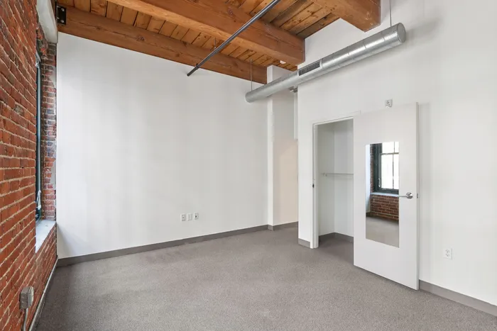 Your bright and airy bedroom offers a peaceful retreat with plenty of natural light pouring in from the windows. | 381 Congress Lofts