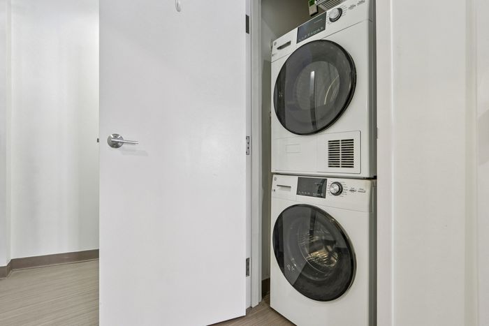 Your modern laundry area features a sleek stacked washer and dryer set, enhancing convenience and efficiency in a compact space. | 381 Congress Lofts