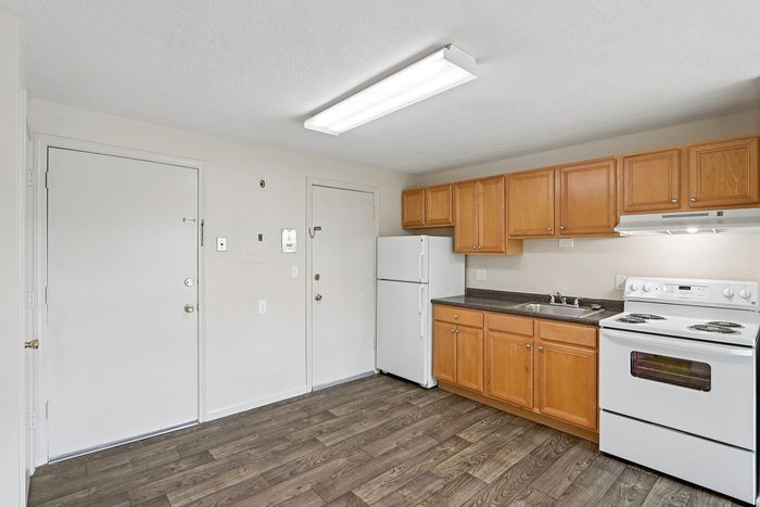Bright and inviting kitchen with modern appliances, elegant wood cabinets, and sleek laminate flooring.