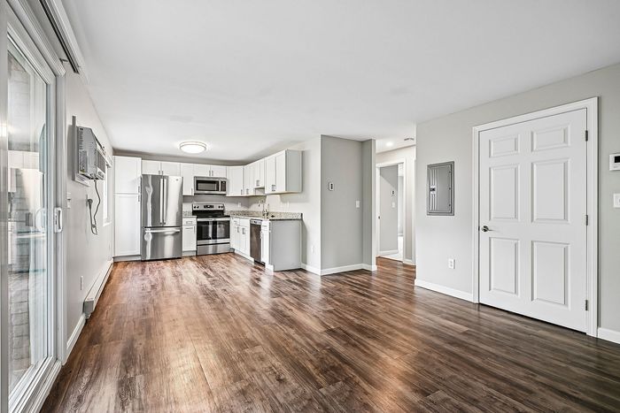 Spacious, modern apartment with sleek wood flooring, stainless steel appliances, and ample natural light.