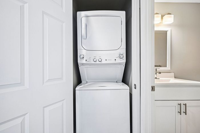 Compact apartment feature with in-unit laundry and modern bathroom, optimizing space and convenience.