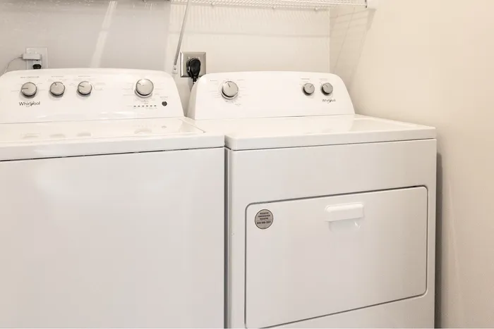 Sleek and modern laundry room featuring state-of-the-art washer and dryer units with convenient shelving.