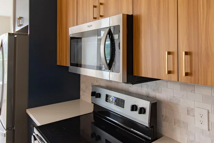 Modern kitchen with sleek stainless steel appliances, elegant wood cabinetry, and a stylish tile backsplash.