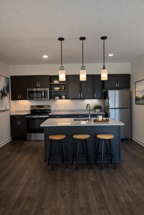 Modern kitchen with sleek dark cabinets, stainless steel appliances, elegant pendant lighting, and a stylish island with seating in a contemporary apartment.