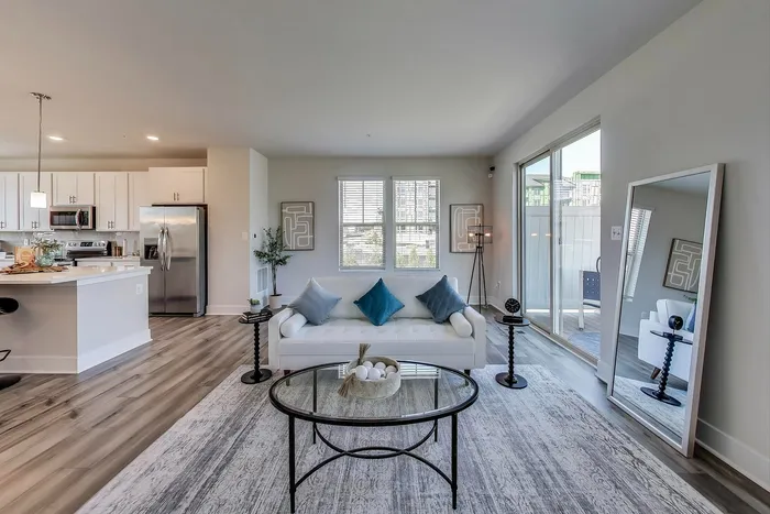 Modern open-concept apartment with bright living room, elegant kitchen, and stylish decor. Features large windows and chic furnishings for a contemporary feel.